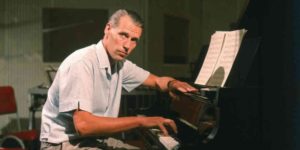 George Martin siede al pianoforte.