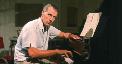 George Martin siede al pianoforte.